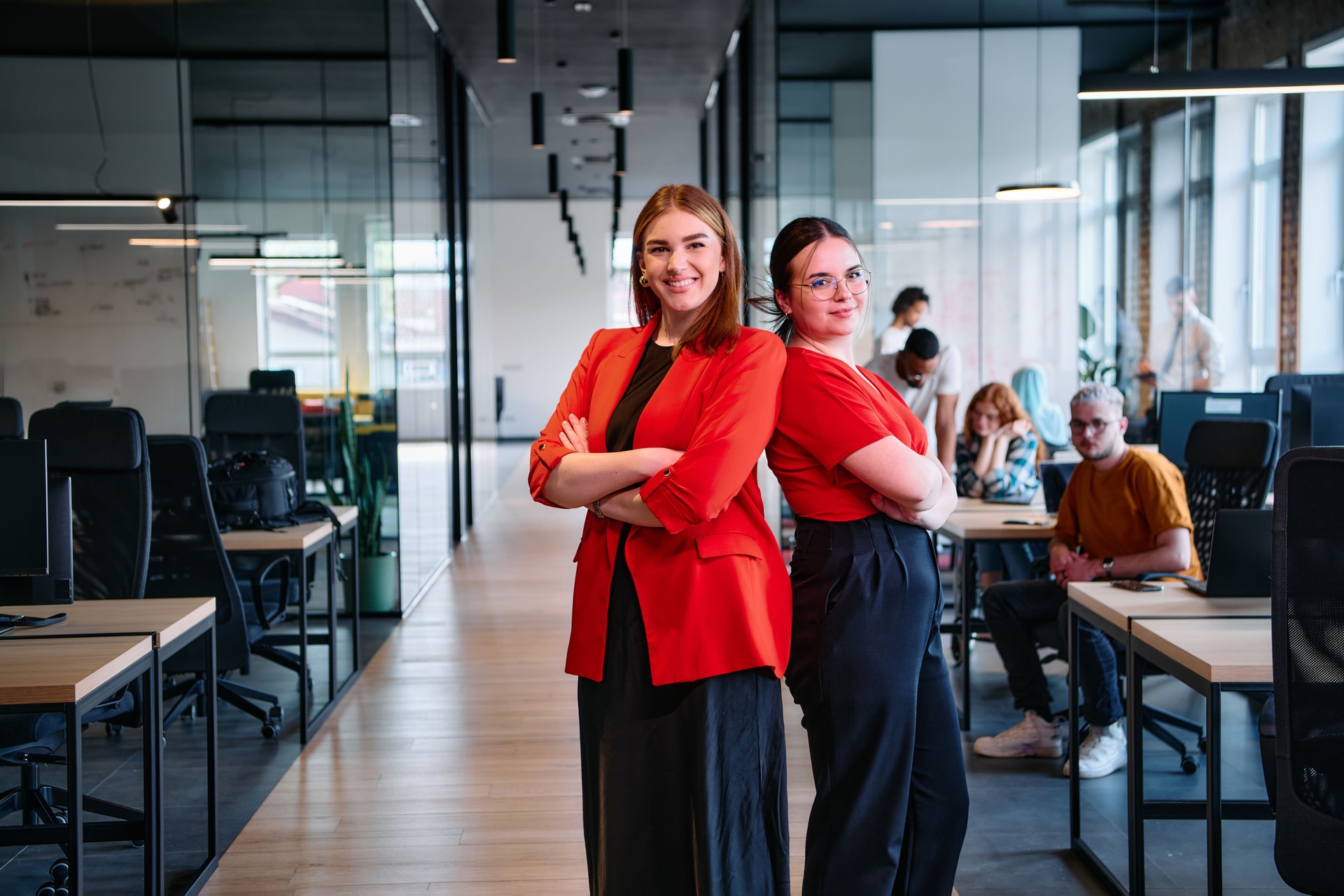 Group of determined businesswomen confidently pose side by side in a modern startup coworking center, embodying professionalism and empowerment